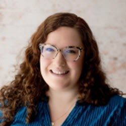 Smiling woman with curly hair and glasses