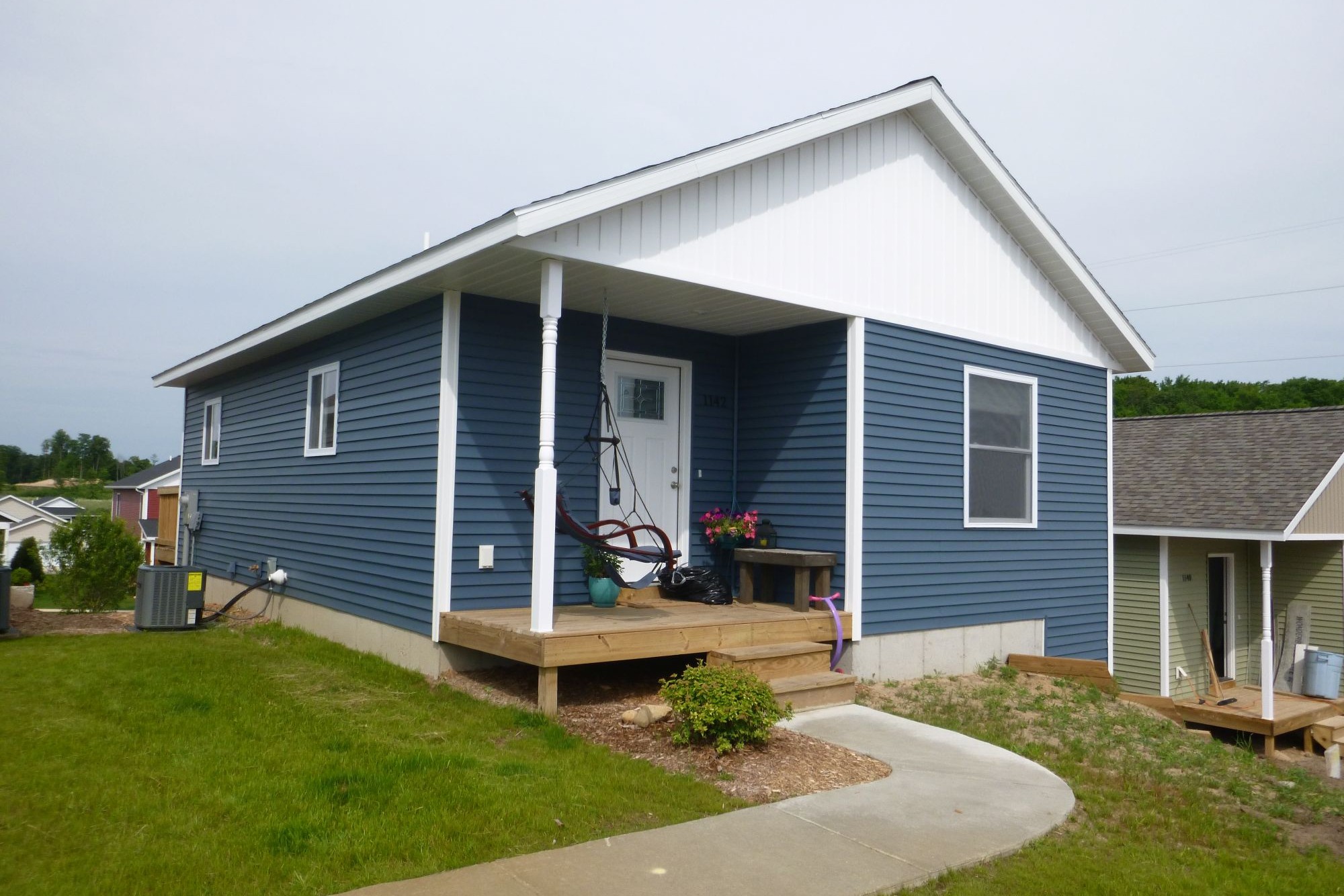 Single-story blue house with porch and swing.