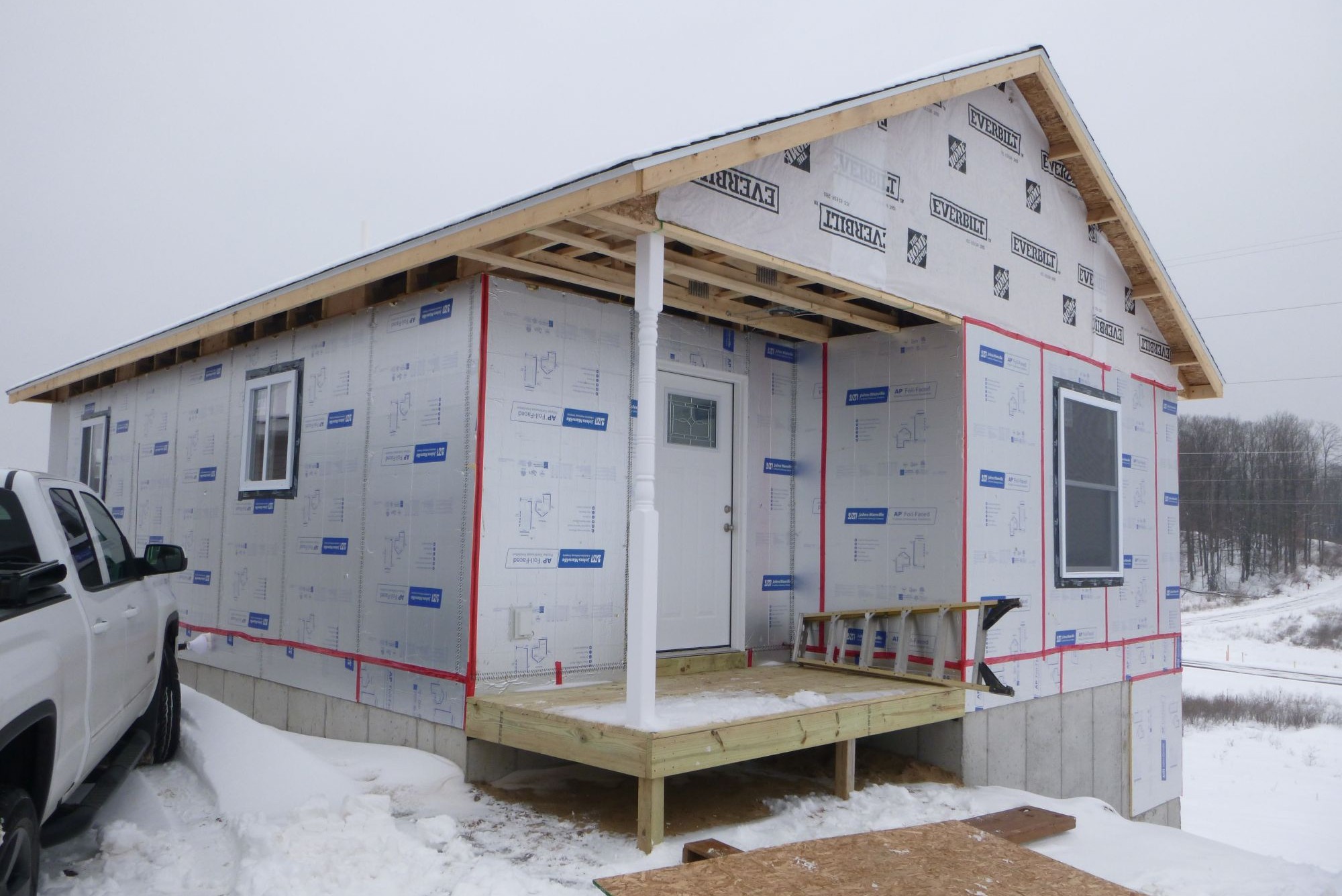 Small house under construction in snowy area.