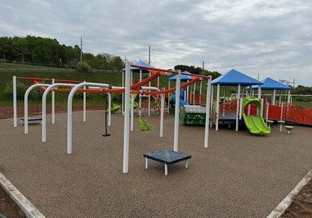 Modern playground with slides and climbing structures.